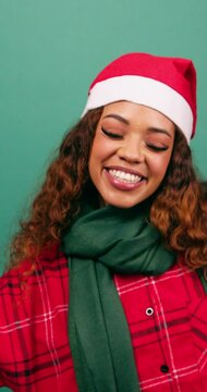 Happy young woman dancing in studio, Christmas theme Santa hat