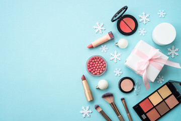 Winter cosmetic with present box and holiday decorations on blue. Christmas sale and gift concept....