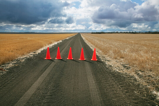 Safety cones lined up across a rural road; Saskatchewan canada
