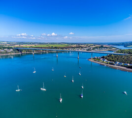 A aerial view past boats moored on the river Cleddau towards the bridge at Pembroke Dock, Wales in summertime