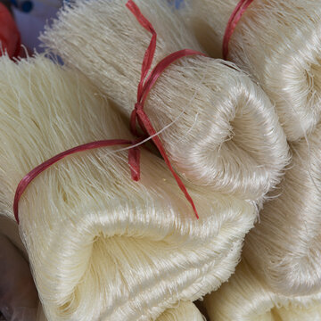 Strands of a white fibre tied with red string in bundles