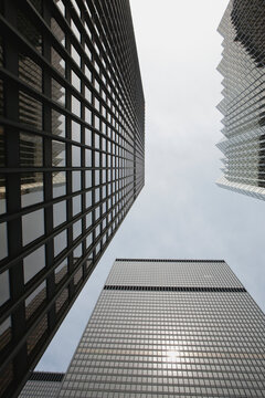 Low angle view of skyscrapers towering and framing blue sky and clouds; Toronto ontario canada