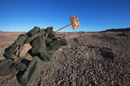 Graphite rocks at dias point and a rusted old sign; Luderitiz namibia