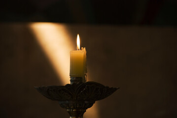 Candle Burning With Sun Ray On The Wall In The Background; Mendoza, Argentina