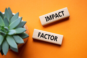 Impact Factor symbol. Wooden blocks with words Impact Factor. Beautiful orange background with succulent plant. Business and Impact Factor concept. Copy space.