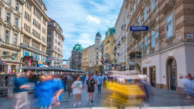 People walking shopping in Graben St. timelapse hyperlapse, old town main street of Vienna with many shops and restaurants, Austria. The column, called The Pestsaule in front,Vienna main street.