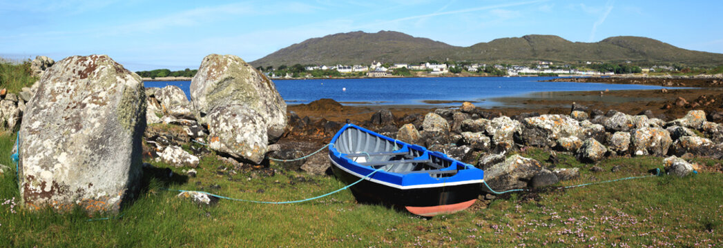 A Boat Tethered On Shore And A View Of Roundstone From Inishnee Island; County Galway, Ireland