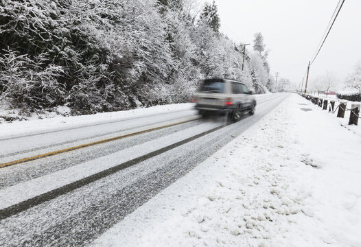 A Vehicle Makes Its Way On Snow Covered Roads On Vancouver Island; Duncan, British Columbia, Canada