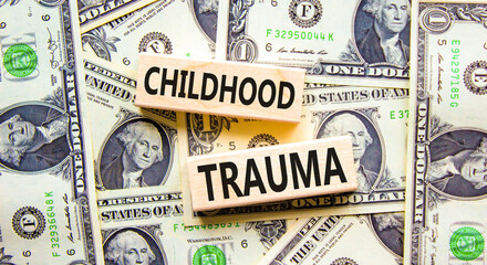 Childhood trauma symbol. Concept words Childhood trauma on beautiful wooden blocks. Dollar bills....