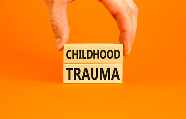 Childhood trauma symbol. Concept words Childhood trauma on beautiful wooden blocks. Beautiful orange background. Psychologist hand. Business psychology childhood trauma concept. Copy space.