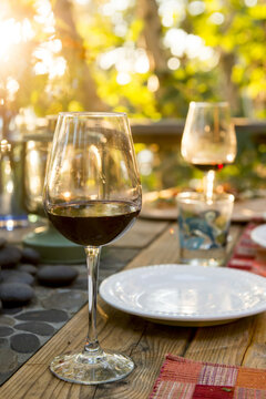 Glasses Of Red Wine On A Table Set For A Meal; Ontario, Canada