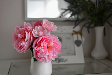 romantyczna rózowa roża w białym wazonie na stoliku, romantyczne tło, rózowa róza w wazonie, róza i ramka ze zdjęciem, romantic pink rose in a white vase on the table, romantic background - obrazy, fototapety, plakaty
