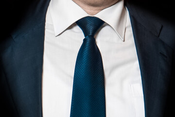 Men's business style clothing fashion white shirt and blue tie and suit jacket close-up soft focus