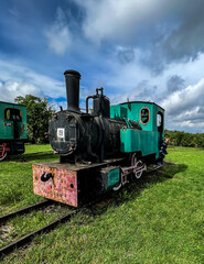 An exhibition of old steam engines on the square next to the historic silver mine in Tarnowskie Góry. A narrow-gauge railway steam locomotive