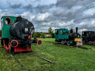 An exhibition of old steam engines on the square next to the historic silver mine in Tarnowskie Góry. A narrow-gauge railway steam locomotive