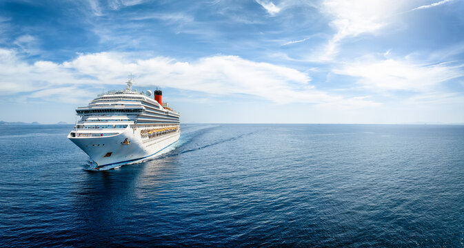 Aerial front view of a generic cruise ship traveling with speed over blue ocean with copy space