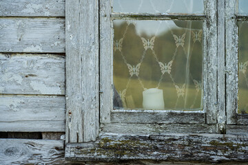 Detail of a window of a white abandoned wooden house.