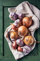 Purple garlic bulbs and onions on a linen towel. Top view. Natural, healthy food ingredients - 648289789