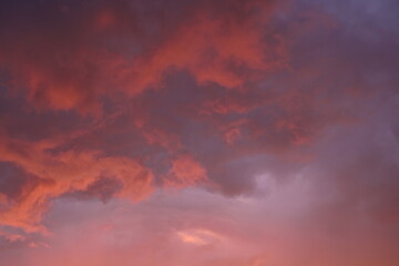 pink blue rainy clouds against the background of the winter sky illuminated by the rays of the sun,...
