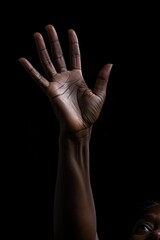 a african american woman reaching up with her hand for help. isolated black background.  reaching out to help. Helping hand. 