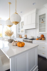White modern kitchen decorated for fall with orange pumpkins and fall leaves