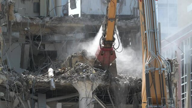 Construction crane demolishing a building to make room for a park