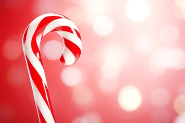 Schilderijen op glas Christmas candy cane, red and white treat on bokeh background with bright lights © Schizarty