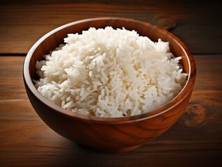 Cooked rice in wooden bowl isolated displayed on wooden background with copy space, concept of carbs, healthy food, Asian food and Asian food culture.