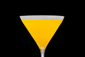 A martini glass with a yellow alcoholic beverage on an black background, close up