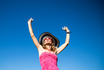 happy woman in pink swimsuit against blue sky holiday concept
