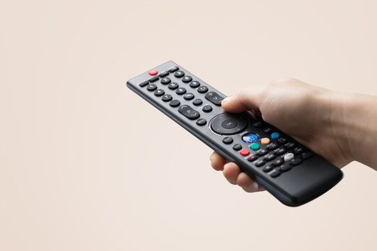 Hand holding classic plastic  tv remote