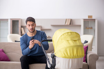 Young man looking after newborn at home