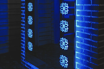 The mirror reflects the interior of the room inside, glass with blue neon lights in dim light