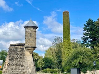 Spanish tower - watch tower turret on a medieval fortification wall in Luxembourg city, Fort Verlorenkost. A chimney covered in green plants behind it.