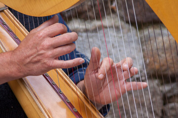 Hände spielen auf einer Harfe