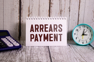 Arrears Payment write on a book isolated on Wooden Table.