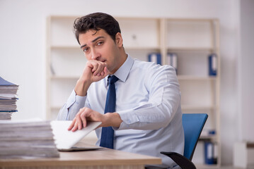 Young male employee and too much work in the office