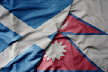 big waving national colorful flag of scotland and national flag of nepal .