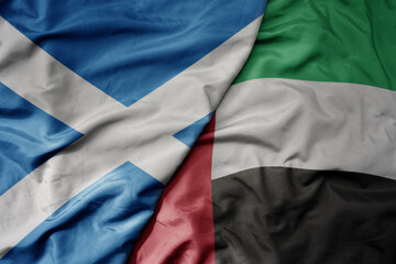 Obraz premium big waving national colorful flag of scotland and national flag of united arab emirates .