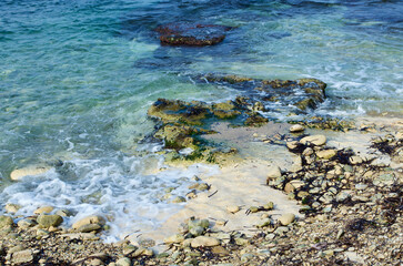 Rocky beach with foamy salt water at the Mediterranean Sea on the island of Malta in autumn.