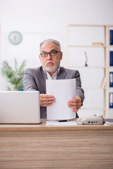 Old male employee working in the office