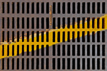 Old Metal grating with diagonal yellow line