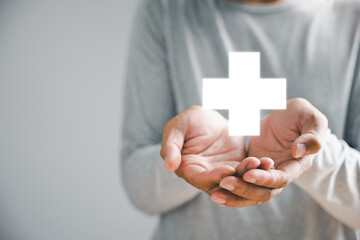Hand holds plus icon for healthcare, symbolizing benefits. Health insurance health concept, access to welfare health and spacious copy area. Illustrates value addition in medical services.