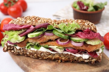 Delicious sandwich with schnitzel on table, closeup