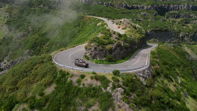 Stunning aerial footage of Land Rover Defender driving through Lombo do Mouro viewpoint on sunny day