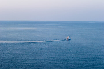 Naklejka premium Single boat in the sea in sunset light, Antalya