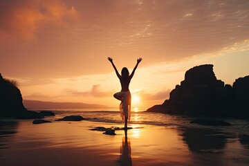 A young woman practicing yoga on the beach at sunset