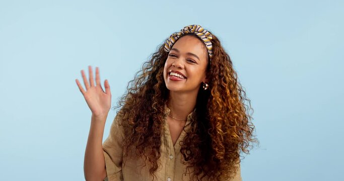 Smile, wave and hello with a friendly woman on a blue background in studio for welcome or greeting. Portrait, excited and happy young person saying goodbye while having fun on a journey as a tourist
