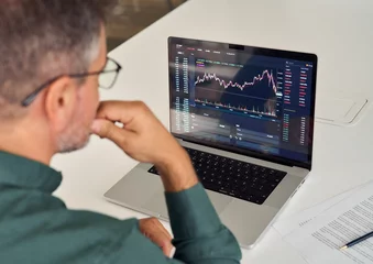 Zelfklevend Fotobehang Investor trader analyzing financial trading crypto stock market checking balance digital data doing investing analysis looking at computer screen thinking of inflation drop risk. Over shoulder view. © insta_photos