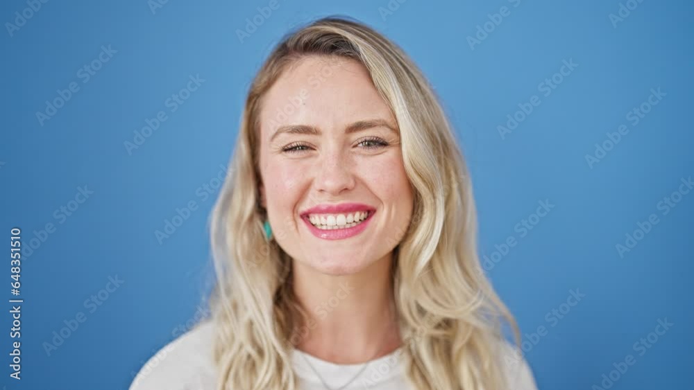 Sticker Young blonde woman smiling confident blowing kiss over isolated blue background